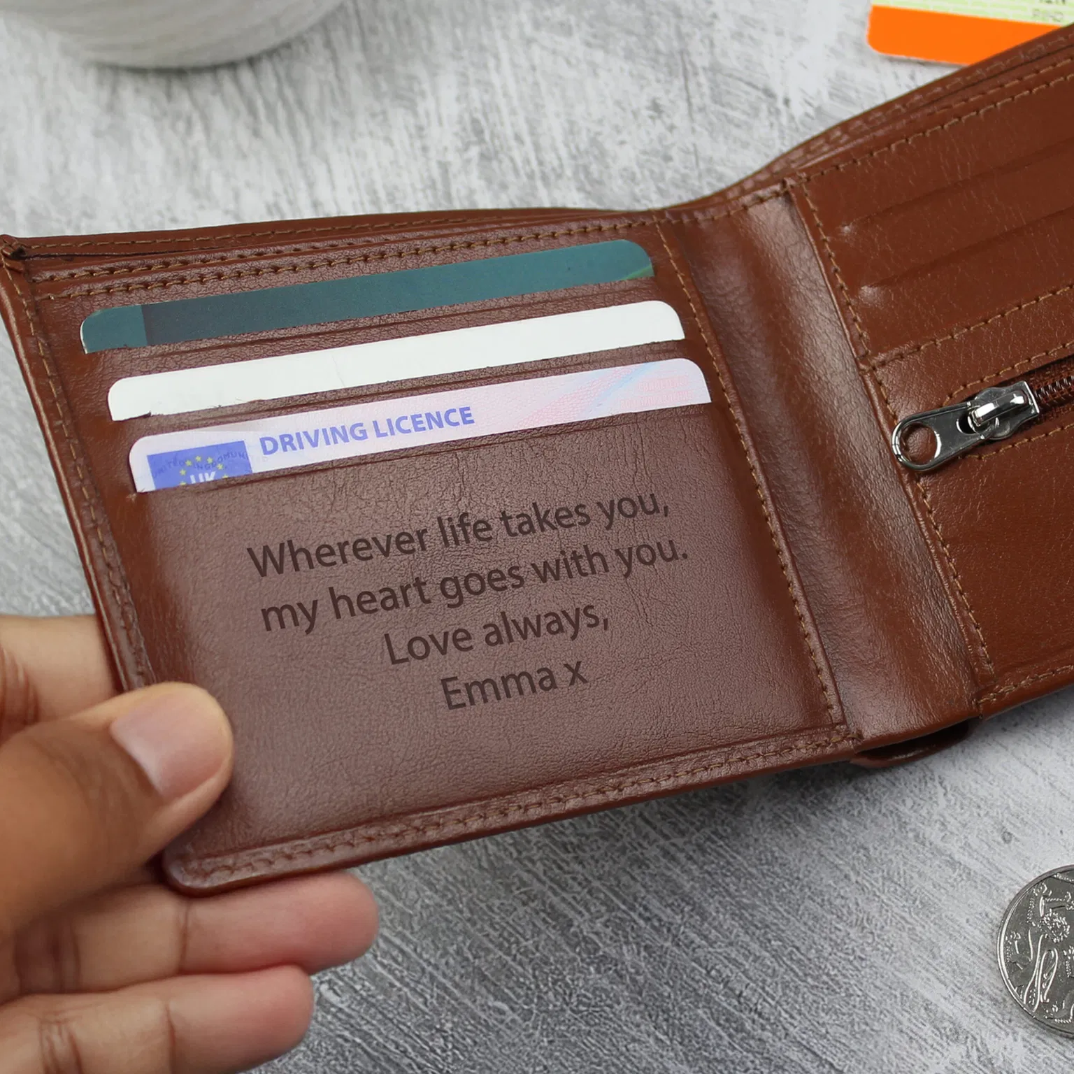 Personalised Brown Leather Wallet: A close-up shot of a high-quality, bi-fold brown leather wallet. The front is custom-engraved with initials, shown resting on a clean, minimalist surface to highlight the natural grain of the leather.