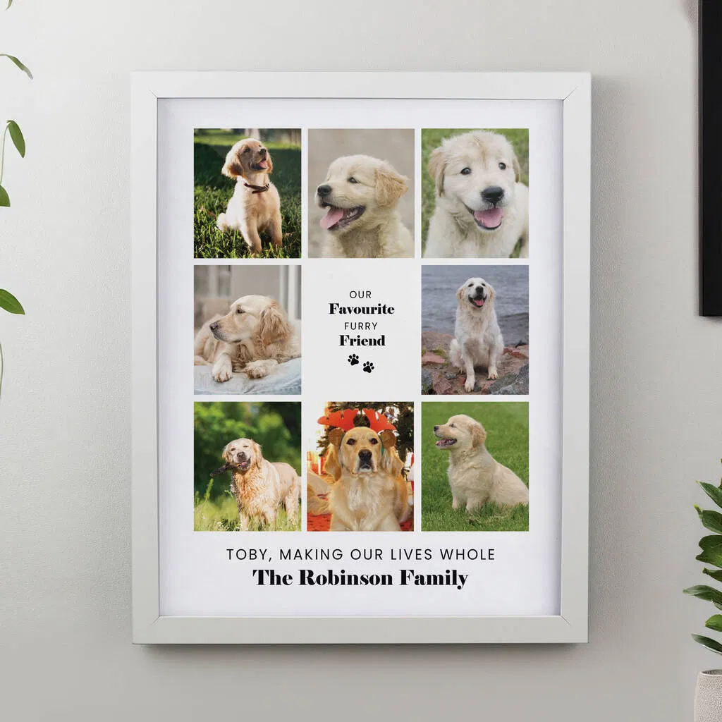A white framed print featuring a nine-photo collage of a Golden Retriever puppy and adult dog in various poses. The center square has the text "OUR FAVOURITE FURRY FRIEND" with paw prints. Below the photo grid is the personalised message: "TOBY, MAKING OUR LIVES WHOLE The Robinson Family".