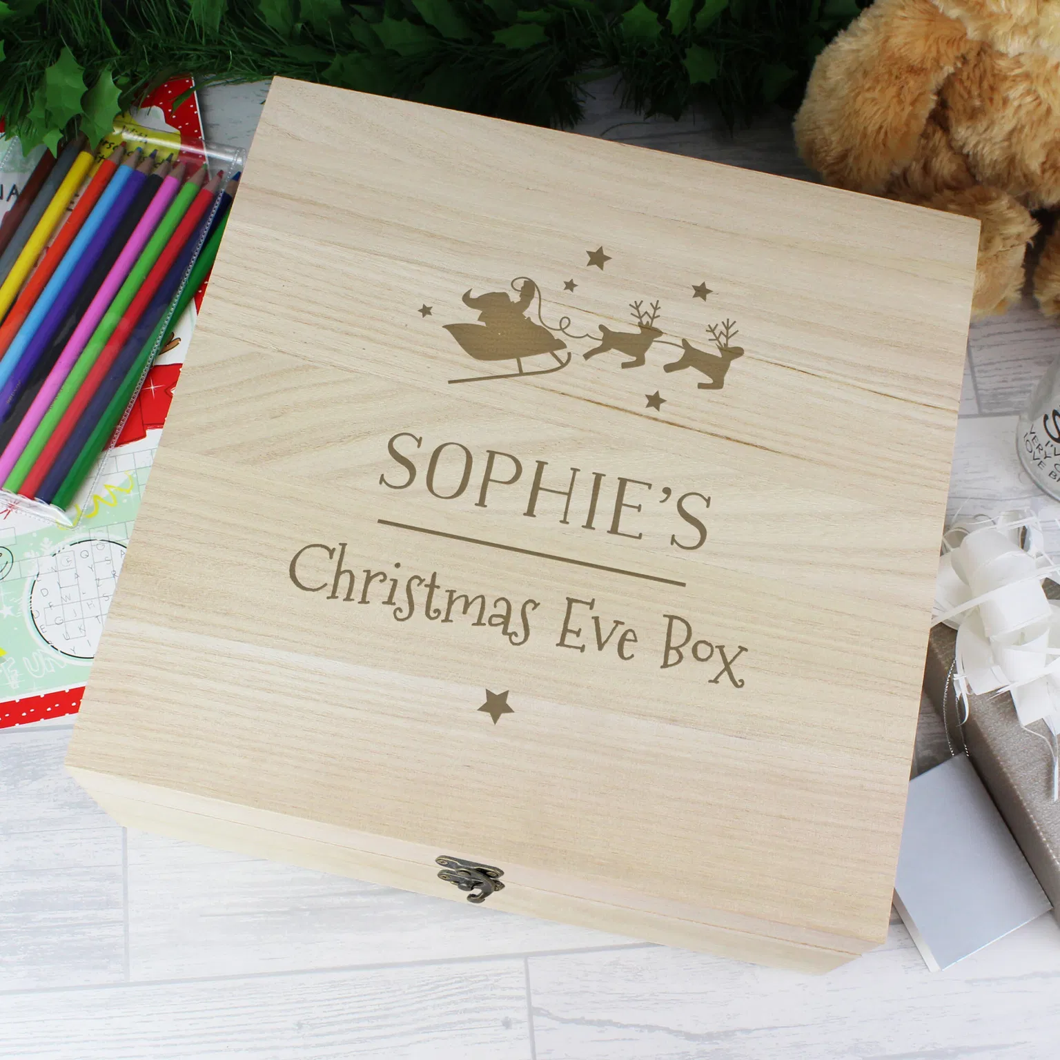 Large personalised wooden Christmas Eve box with a hinged lid and metal clasp, engraved with a name, 'Christmas Eve Box,' and Santa's sleigh silhouette.