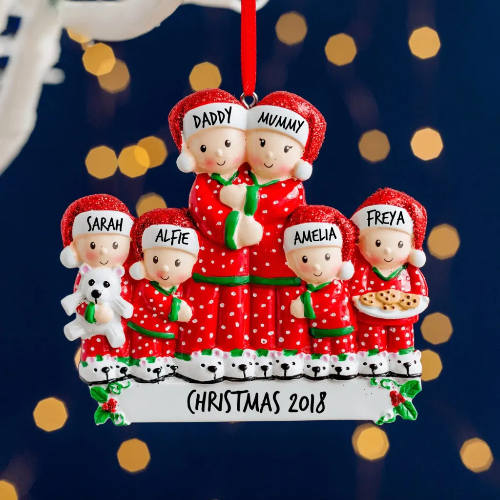 Personalised resin Christmas tree decoration featuring a family of six in matching red and white pyjamas, hung against a blurred festive background.