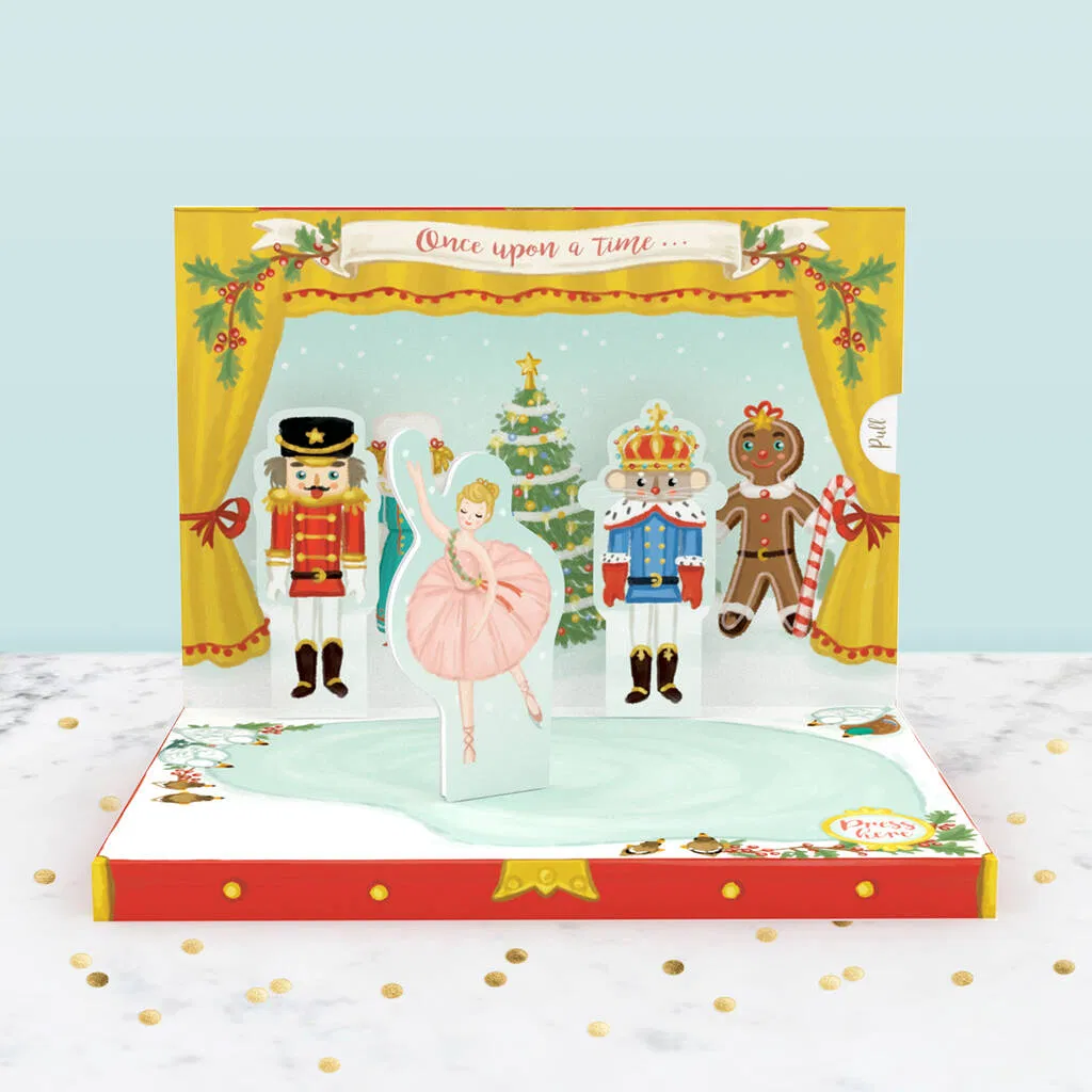 Pop-up Christmas card shaped like a theater stage, featuring characters from The Nutcracker ballet, including the Sugar Plum Fairy, Nutcracker, and Gingerbread Man, which functions as a wind-up music box.