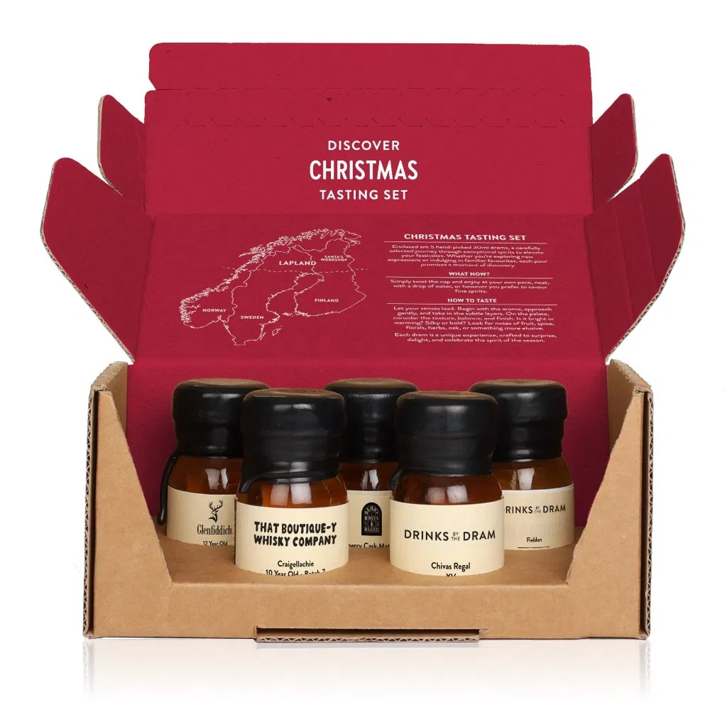 Open Christmas Whisky Tasting Set box showing five 30ml wax-sealed whisky samples inside. The box lid features tasting instructions and a map of Christmas regions like Lapland.