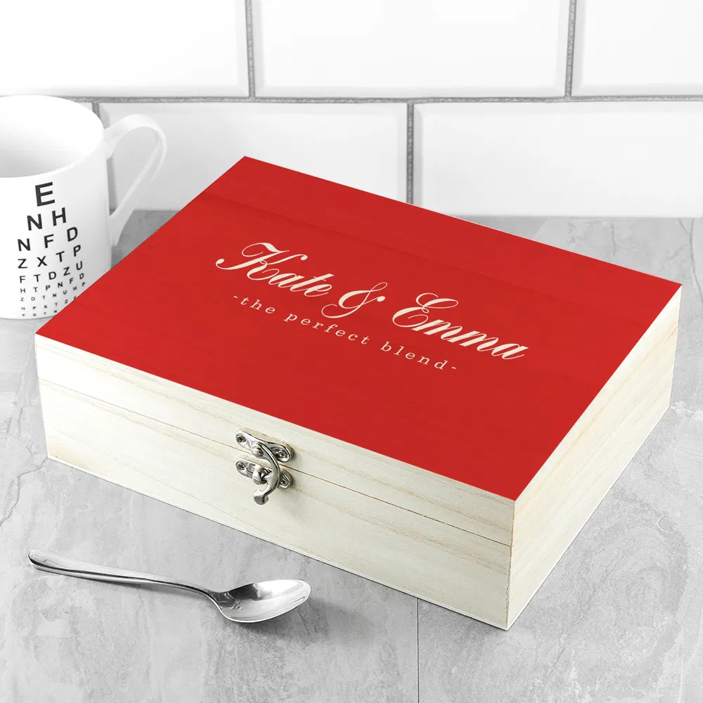 Vibrant red and natural wood tea chest engraved with 'The Perfect Blend', shown as a complete gift set with a selection of traditional and herbal tea bags.