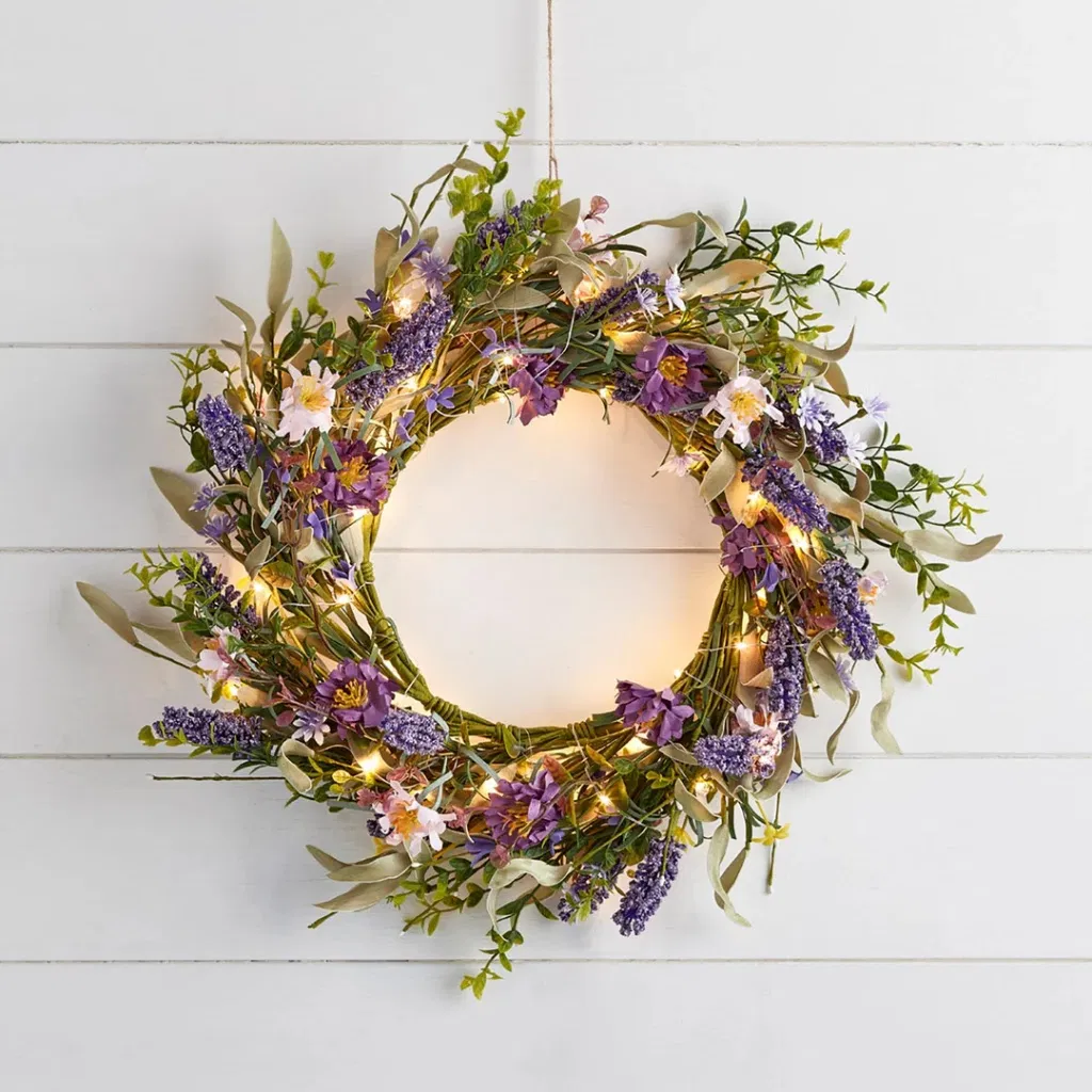 45cm Spring Lavender Wreath: A 45cm spring wreath featuring faux purple lavender, wildflowers, and green foliage with glowing warm white micro LED lights, hanging on a white wooden shiplap wall.