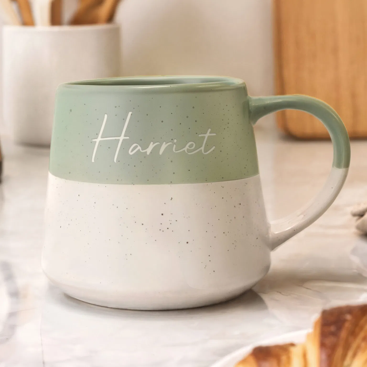 Personalised Green Ceramic Mug: A handcrafted green ceramic mug with a dark speckled glaze. The name is precisely engraved into the surface, showing the contrast against the rich green finish.