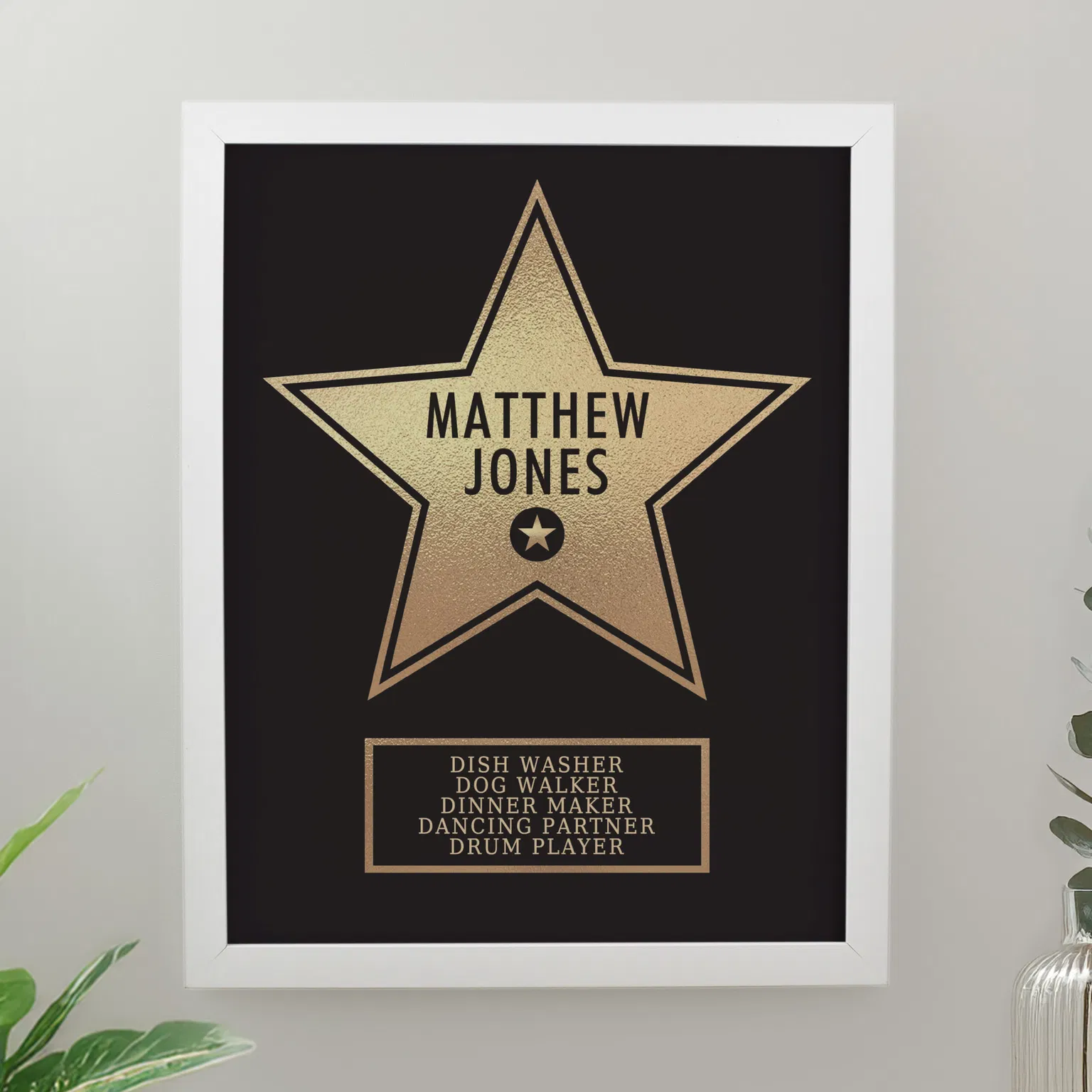 Personalised Hollywood Star Frame: A custom gold star print in a modern white frame. The star features the name "Matthew Jones" and a list of humorous roles including "Dish Washer" and "Dancing Partner."