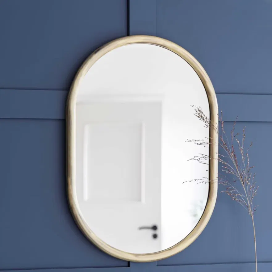 An antique brass arched wall mirror styled above a vintage washbasin bathroom vanity by Abode Home & Gifts.