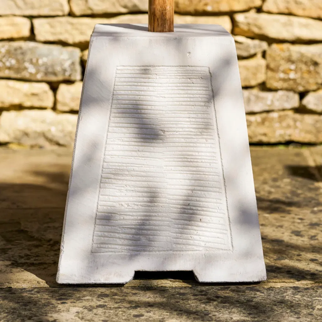 Front-on view of the white Brighton parasol base highlighting the textured finish and square silhouette.
