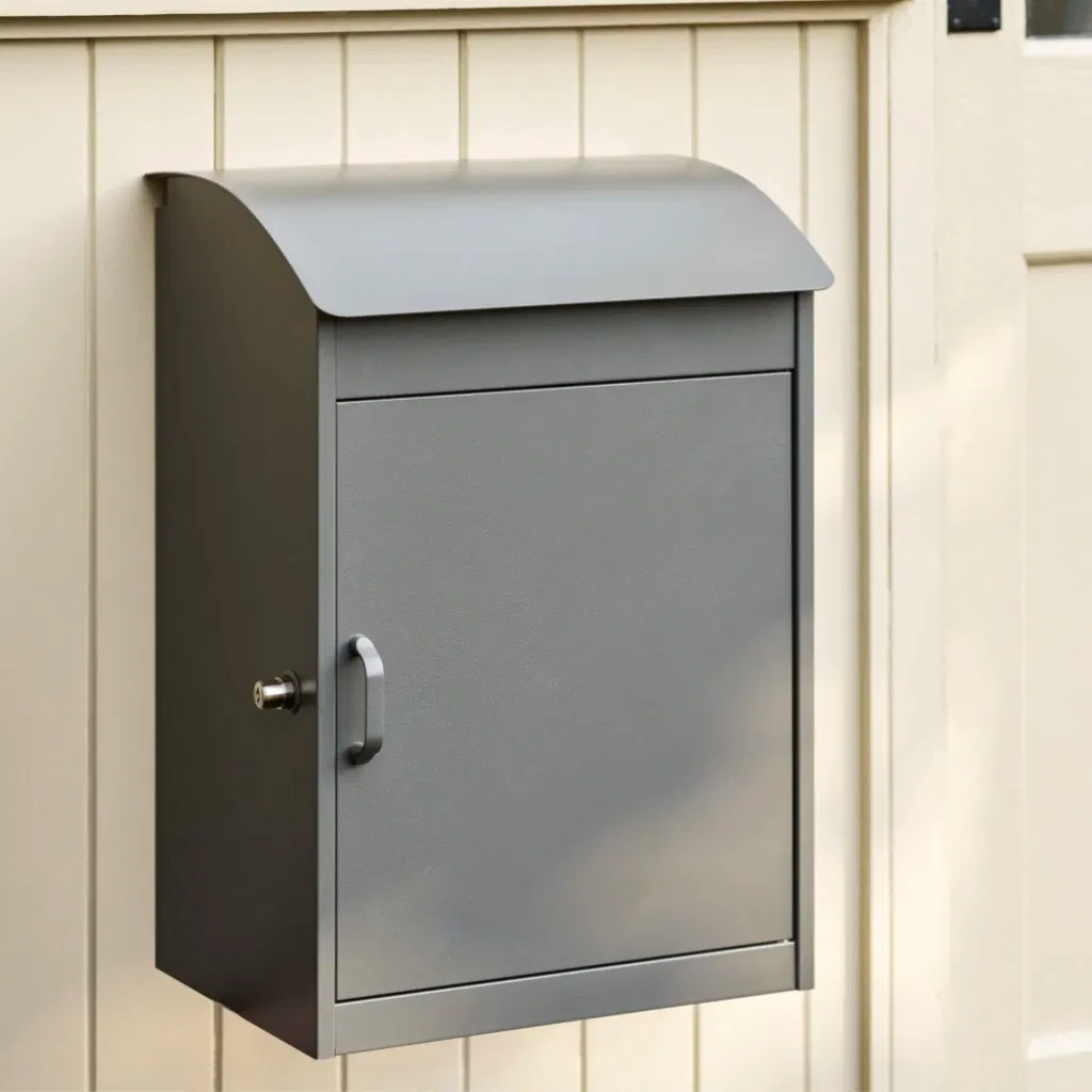 A charcoal grey metal parcel box mounted on a cream wooden wall with a secure lock and handle.