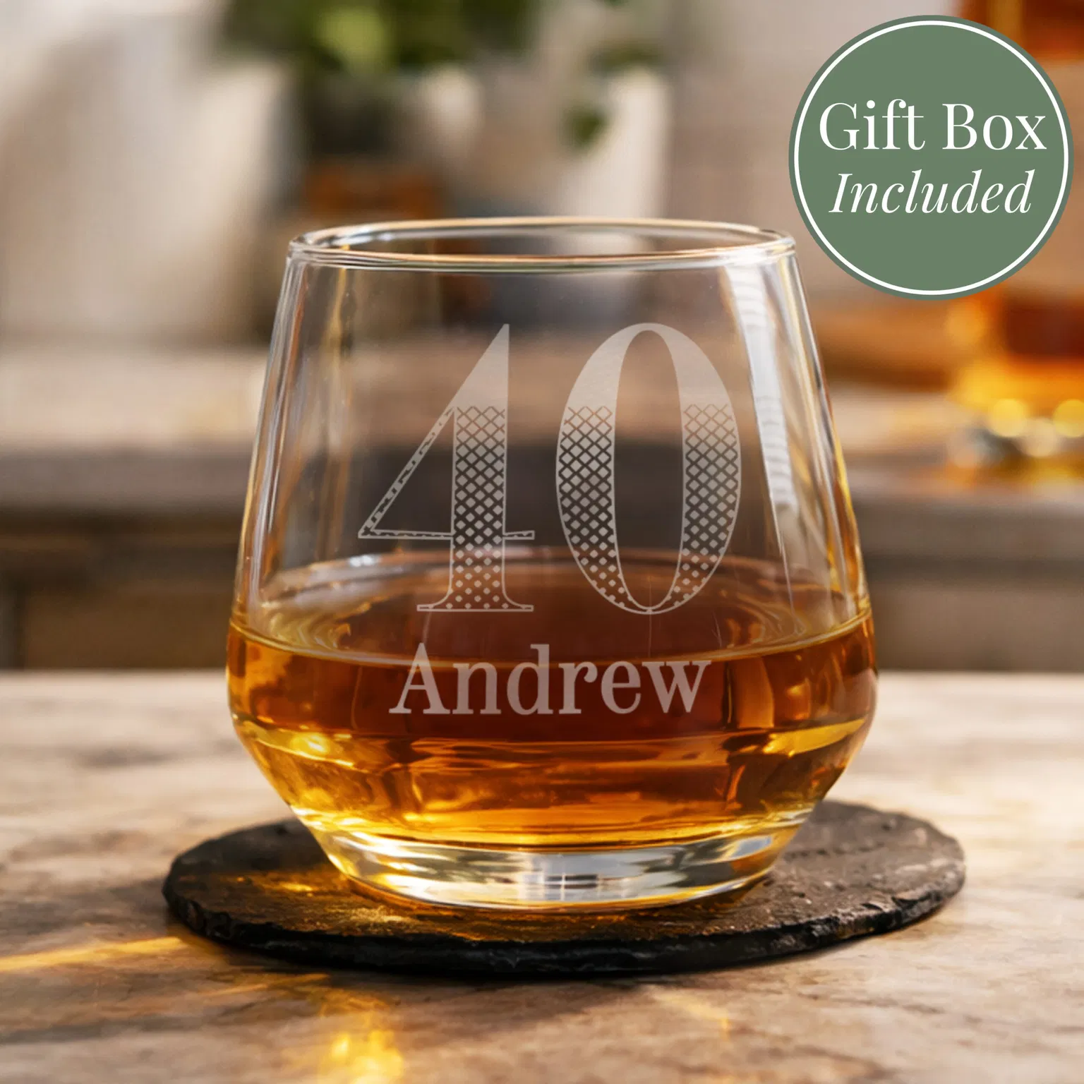 A personalised 40th birthday tumbler by Abode Home & Gifts filled with amber whisky, resting on a rustic slate coaster.
