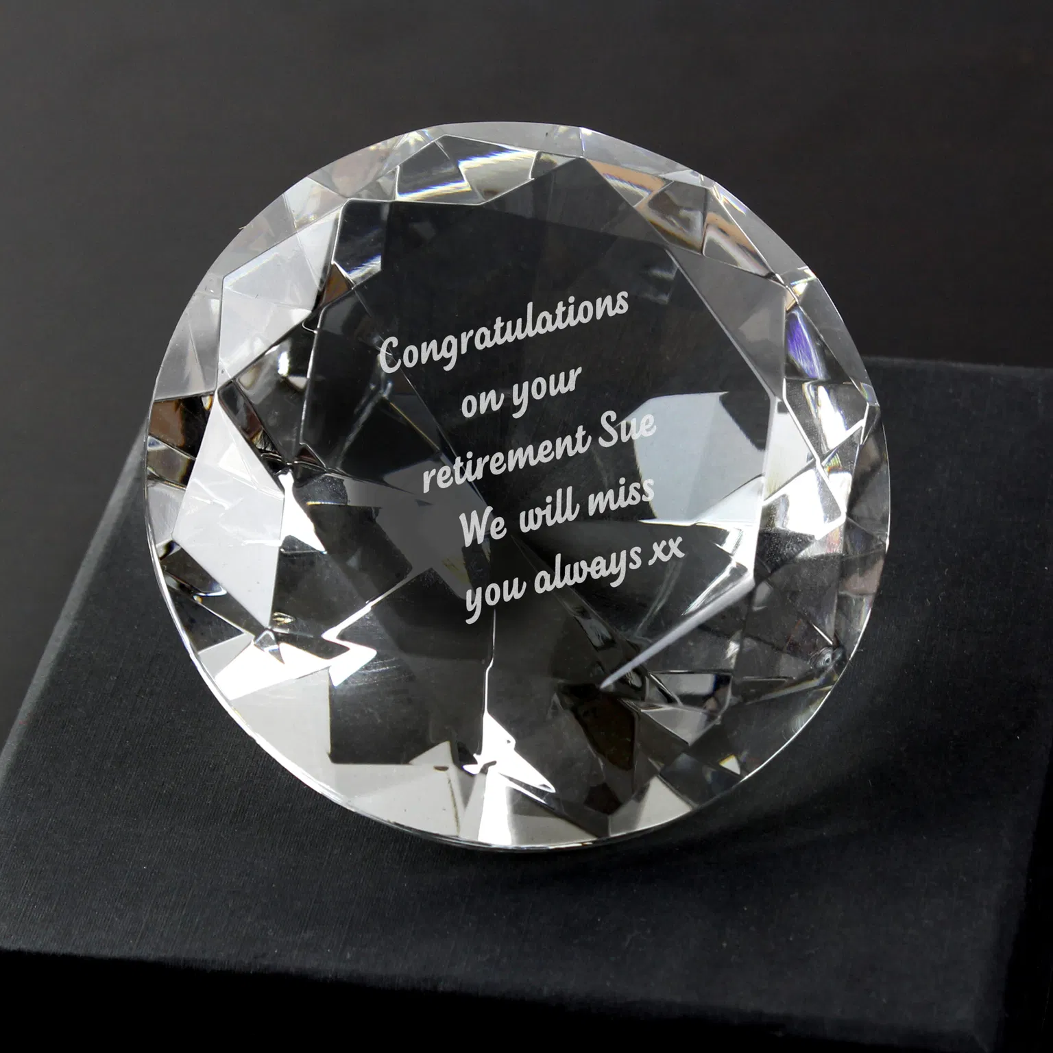Custom engraved crystal diamond paperweight resting in a black silk lined gift box reading Happy Retirement On your next adventure.